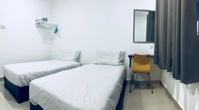 a room with two beds and a chair in it at LunaStay (Shared Common Area) in Lunas