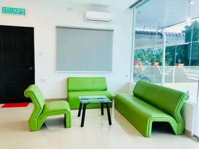 two green chairs and a table in a room at LunaStay (Shared Common Area) in Lunas
