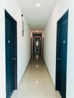 an empty hallway with two green doors and a hallway at LunaStay (Shared Common Area) in Lunas