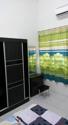 a room with a cabinet and a window and a rug at Homestay Kuala Kangsar in Kuala Kangsar