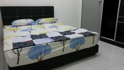 a bed with a quilt and pillows on it at Homestay Kuala Kangsar in Kuala Kangsar