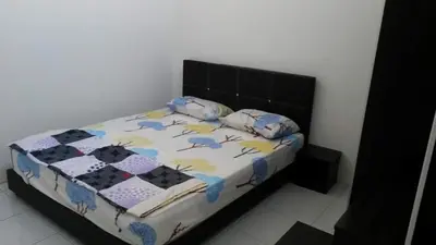 a bedroom with a bed with a black headboard at Homestay Kuala Kangsar in Kuala Kangsar