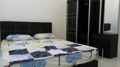 a bedroom with a bed with a black headboard at Homestay Kuala Kangsar in Kuala Kangsar