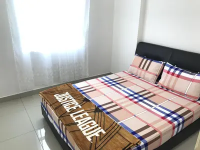 a bed with a comforter and pillows in a room at Spice Tunas 3B2B House in Bayan Lepas