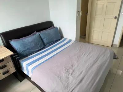 a bed with blue and white sheets in a room at Spice Tunas 3B2B House in Bayan Lepas