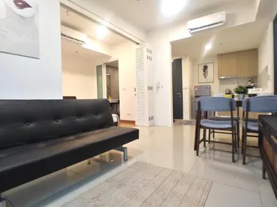 a living room with a black couch and a kitchen at Georgetown City View Condo Tropicana 218 Macalister in George Town