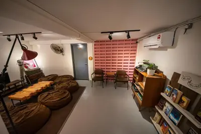 a living room with a couch and a table and chairs at The Brownstone Hostel & Space in Ipoh