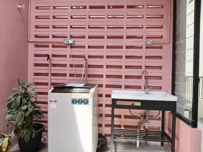 a bathroom with a sink and a pink wall at The Brownstone Hostel & Space in Ipoh