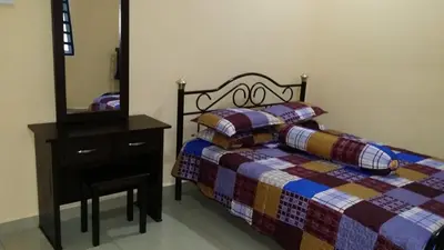 a bedroom with a bed and a dresser and a mirror at IsMa Lumut Homestay in Lumut
