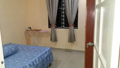 a bedroom with a bed and a window with curtains at IsMa Lumut Homestay in Lumut