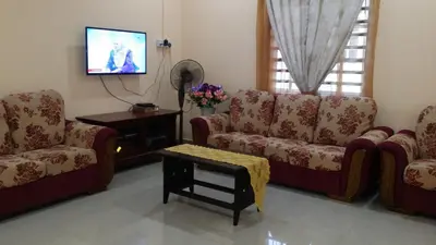 a living room with two couches and a tv at IsMa Lumut Homestay in Lumut