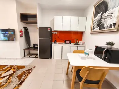 a kitchen with a table and a black refrigerator at 3 Concordia @ Gurney in George Town