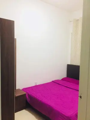 a bedroom with a bed with a pink bedspread at Ainul MarDhiah @ Cameron Highland (muslim stay) in Cameron Highlands