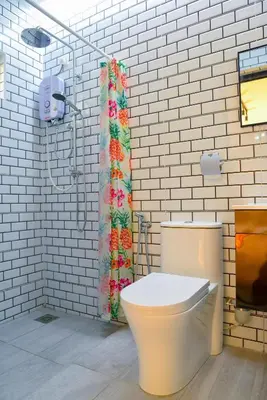 a bathroom with a toilet and a shower curtain at Purple Cube at Lumut Cube Homestay Kontena in Lumut