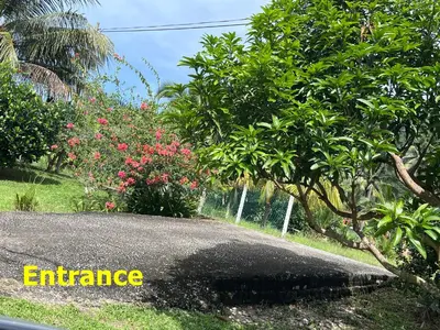 an entrance sign in front of a garden with trees at Purple Cube at Lumut Cube Homestay Kontena in Lumut