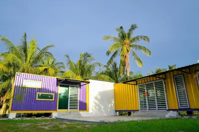 a row of houses with colorful doors and palm trees at Purple Cube at Lumut Cube Homestay Kontena in Lumut