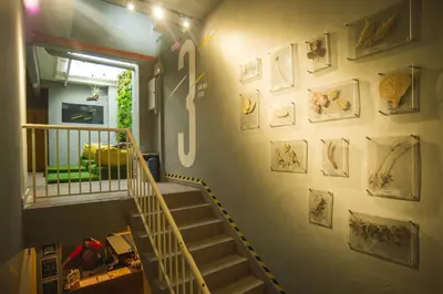 a hallway with a staircase with pictures on the wall at Traveller Bunker Hostel 1 in Cameron Highlands