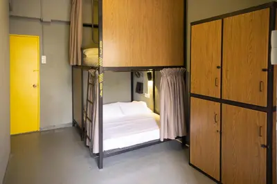 a small room with a bed and a closet at Traveller Bunker Hostel 1 in Cameron Highlands