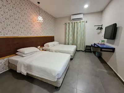a hotel room with two beds and a television at Hotel Bestari in Kuala Lipis