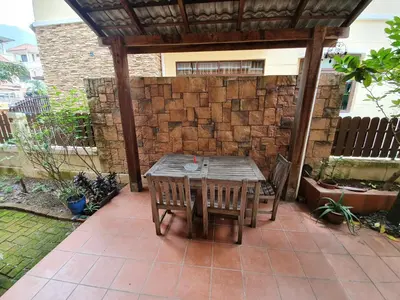 a wooden table and chairs on a patio at Eden Cosy Living in Batu Ferringhi