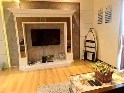 a living room with a fireplace with a flat screen tv at Sekinchan PaddyView Homestay \u9ad8\u697c \u770b\u7a3b\u7530 \u9633\u53f0\u6c11\u5bbf in Sekincan