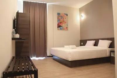 a bedroom with a bed and a bench in it at Gergasi Inn in Ipoh