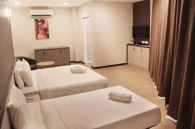 a hotel room with two beds and a television at Gergasi Inn in Ipoh