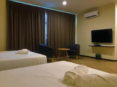 a hotel room with two beds and a flat screen tv at Gergasi Inn in Ipoh