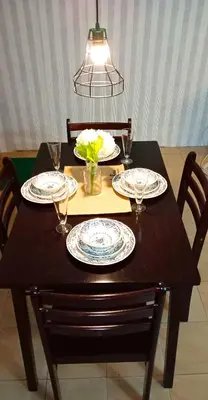 a wooden table with plates and glasses on it at Rumah Tamu Azizah in Kampong Tanjong Bayan