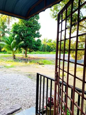 a gate with a view of a park behind it at Rumah Tamu Azizah in Kampong Tanjong Bayan