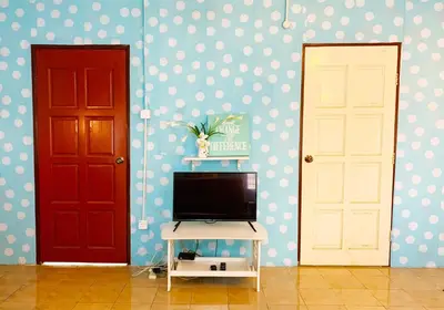 a room with two doors and a television on a table at Rumah Tamu Azizah in Kampong Tanjong Bayan