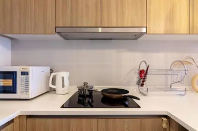 a kitchen with a stove with a frying pan on it at Tropicana 218 X Airlevate Suites in George Town