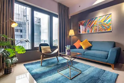 a living room with a blue couch and a large window at Tropicana 218 X Airlevate Suites in George Town