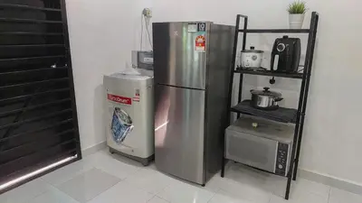 a kitchen with a stainless steel refrigerator and a shelf at D'Sandra Homestay in Kulim