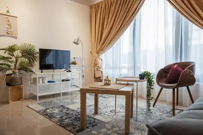 a living room with a couch and a table and a tv at Xandra's 218 Macalister Suite in George Town