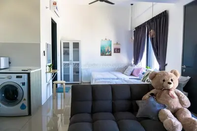 a teddy bear sitting on a couch in a living room at Xandra's 218 Macalister Suite in George Town