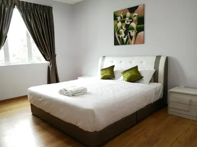 a bedroom with a large white bed with green pillows at Omni Cassia Hill Resort in Cameron Highlands