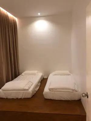 a bedroom with two beds and a light on the wall at Brand New Apartment in Local Neighbourhood in Ringlet