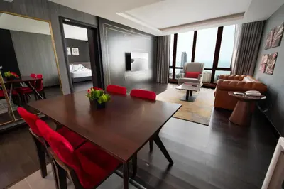 a living room with a wooden table and red chairs at Jazz Hotel Penang in George Town