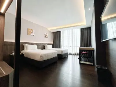 a hotel room with two beds and a couch at Jazz Hotel Penang in George Town