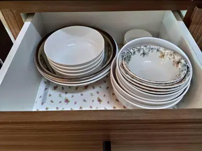 a stack of plates and bowls in a drawer at Plumber house in Tanah Rata