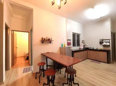 a kitchen with a table and stools in a room at Plumber house in Tanah Rata