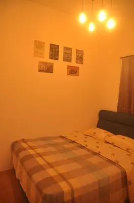 a bedroom with a bed with a checkered blanket at Plumber house in Tanah Rata