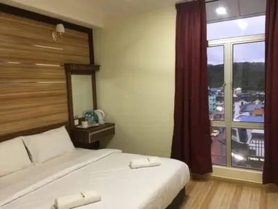 a bedroom with a bed and a large window at Haji Saudi Hotel in Cameron Highlands