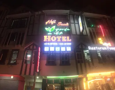 a building with a hotel sign on it at night at Haji Saudi Hotel in Cameron Highlands