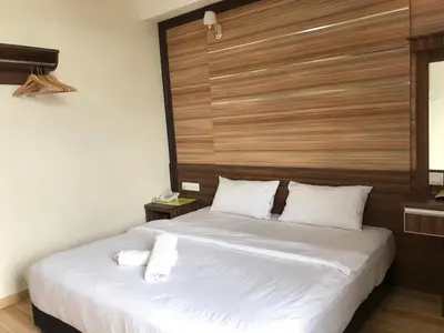a bedroom with a large bed with a wooden headboard at Haji Saudi Hotel in Cameron Highlands