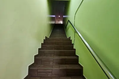 a staircase in a building with green walls and a stair case at Nova Hotel, Ipoh Tambun in Ipoh