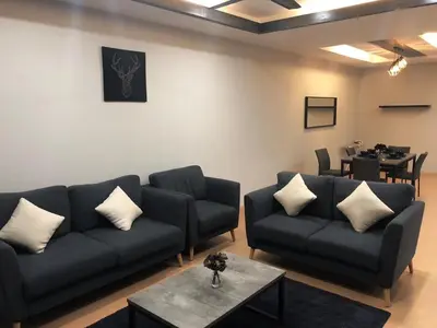 a living room with two couches and a table at Meena's Apartment @ The Quintet in Cameron Highlands