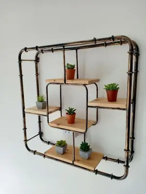 a metal pipe shelf with potted plants on it at On Cloud 9 @ CEO by Joal in Bayan Lepas