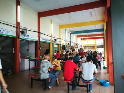 a group of people sitting at tables in a restaurant at On Cloud 9 @ CEO by Joal in Bayan Lepas